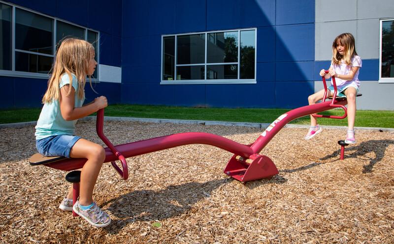 Girls riding see-saw