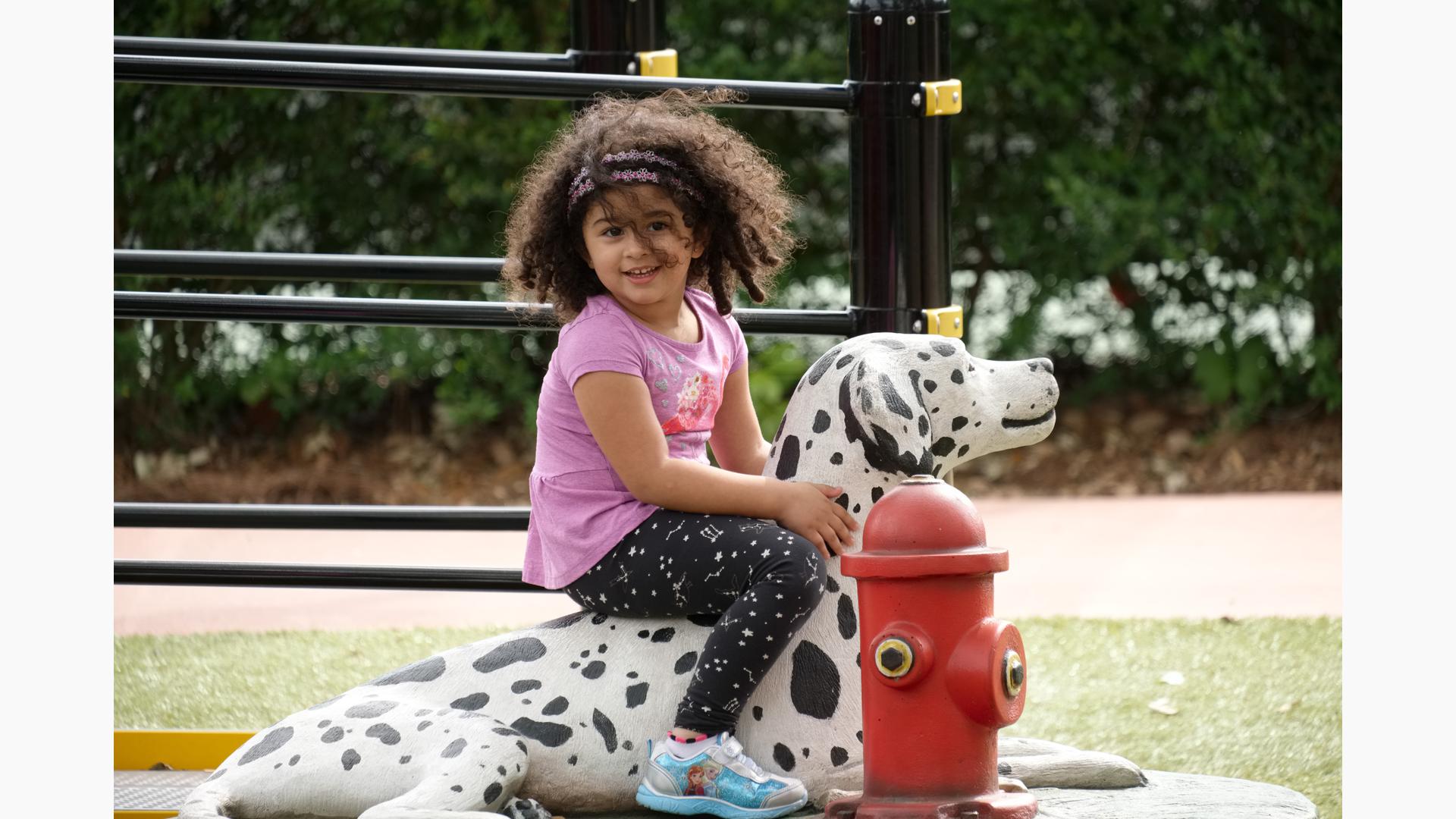 Girl siting on Dalmatian statue