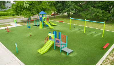 Elevated view of a play area with synthetic grass and many playground activities.