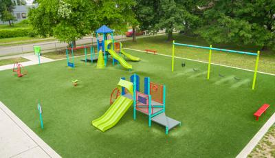 Elevated view of a play area with synthetic grass and many playground activities.