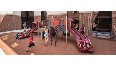Parents watch their children on PlayShaper play structure in courtyard.