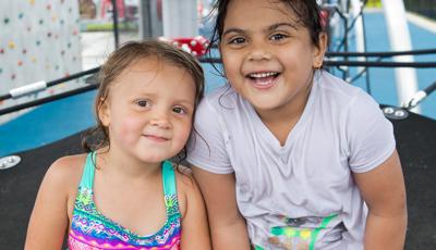Two girls smiling whiling sitting in disc set