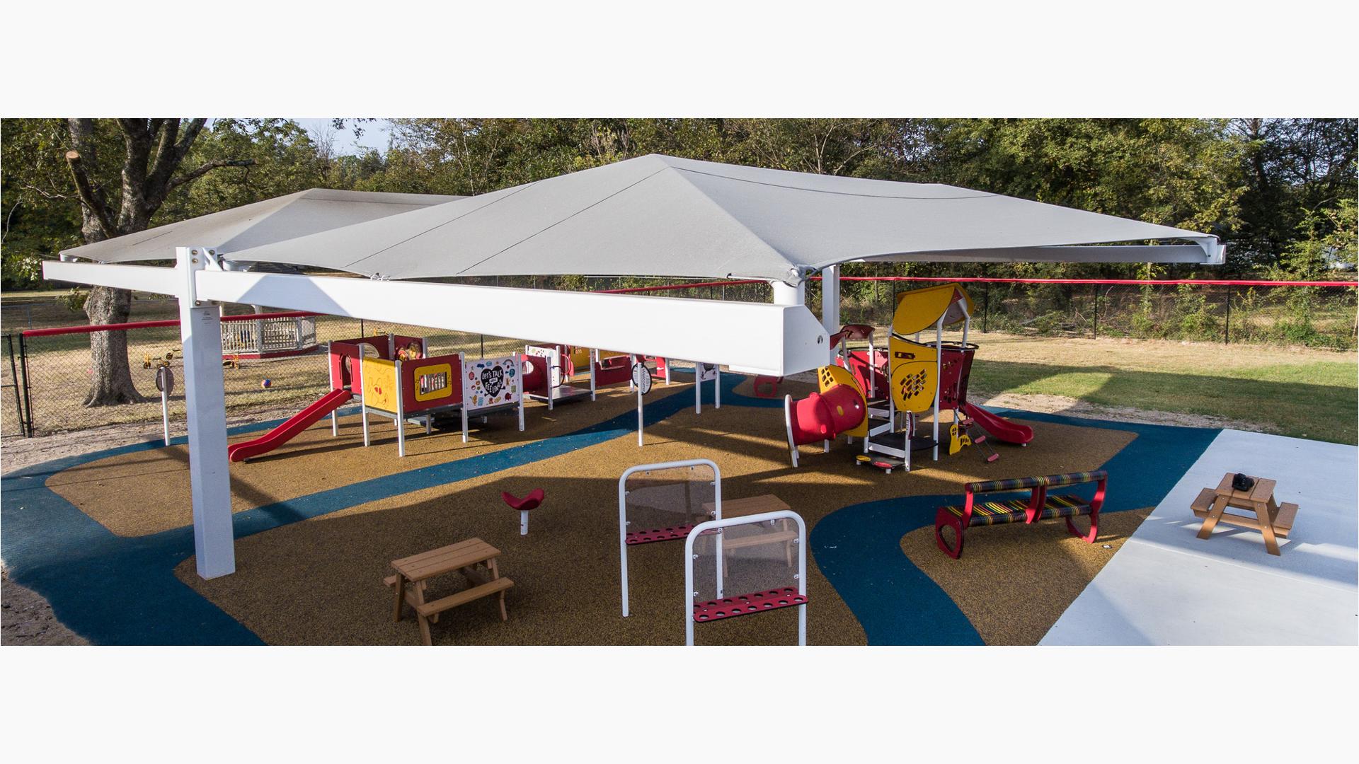As part of Pooh Bear Daycare Center, this smart play playground sits under a shade canopy as the sun sets.