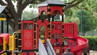 Man sitting in front of Common Ground play structure