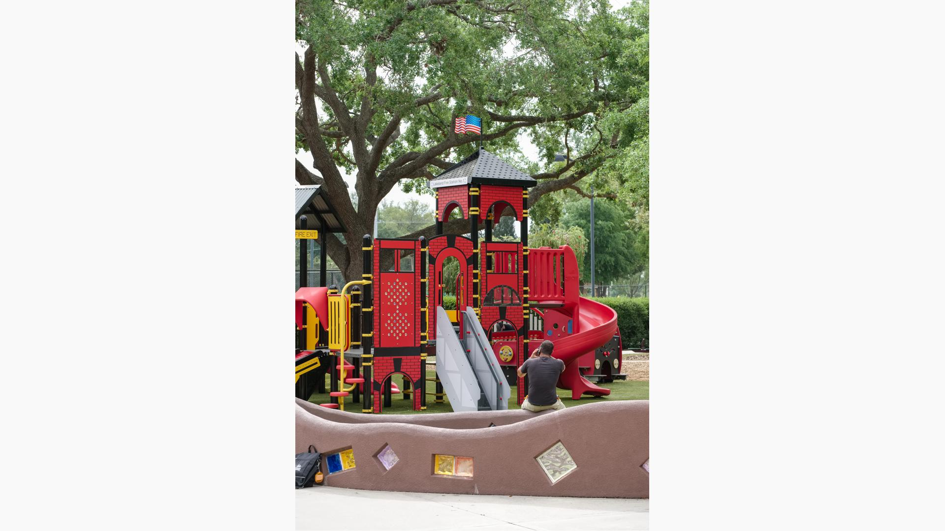 Man sitting in front of Common Ground play structure