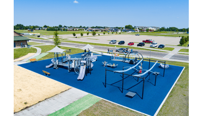 Elevated view of children playing on playground equipment and blue colored safety surfacing.