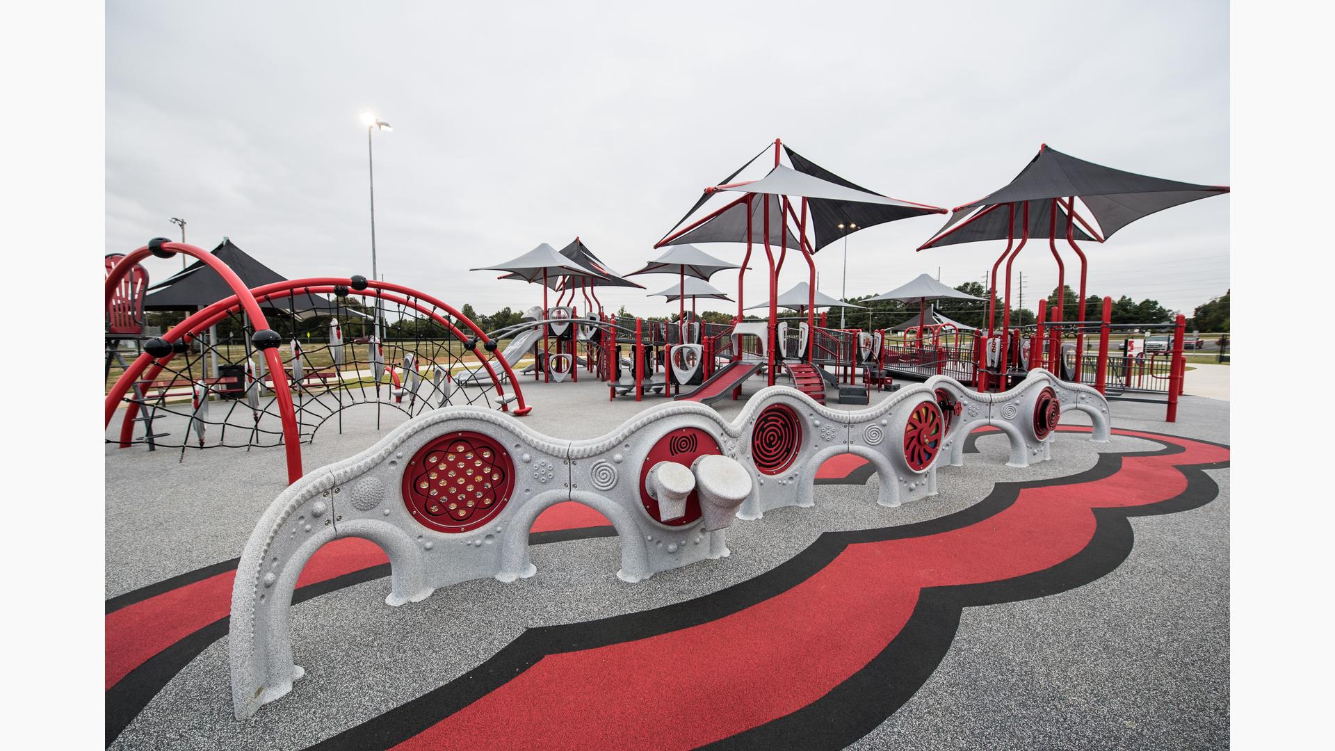 All inclusive playground featuring Evos and PlayBooster equipment. The playground has a custom surface and shade coverings over each of the play structures.