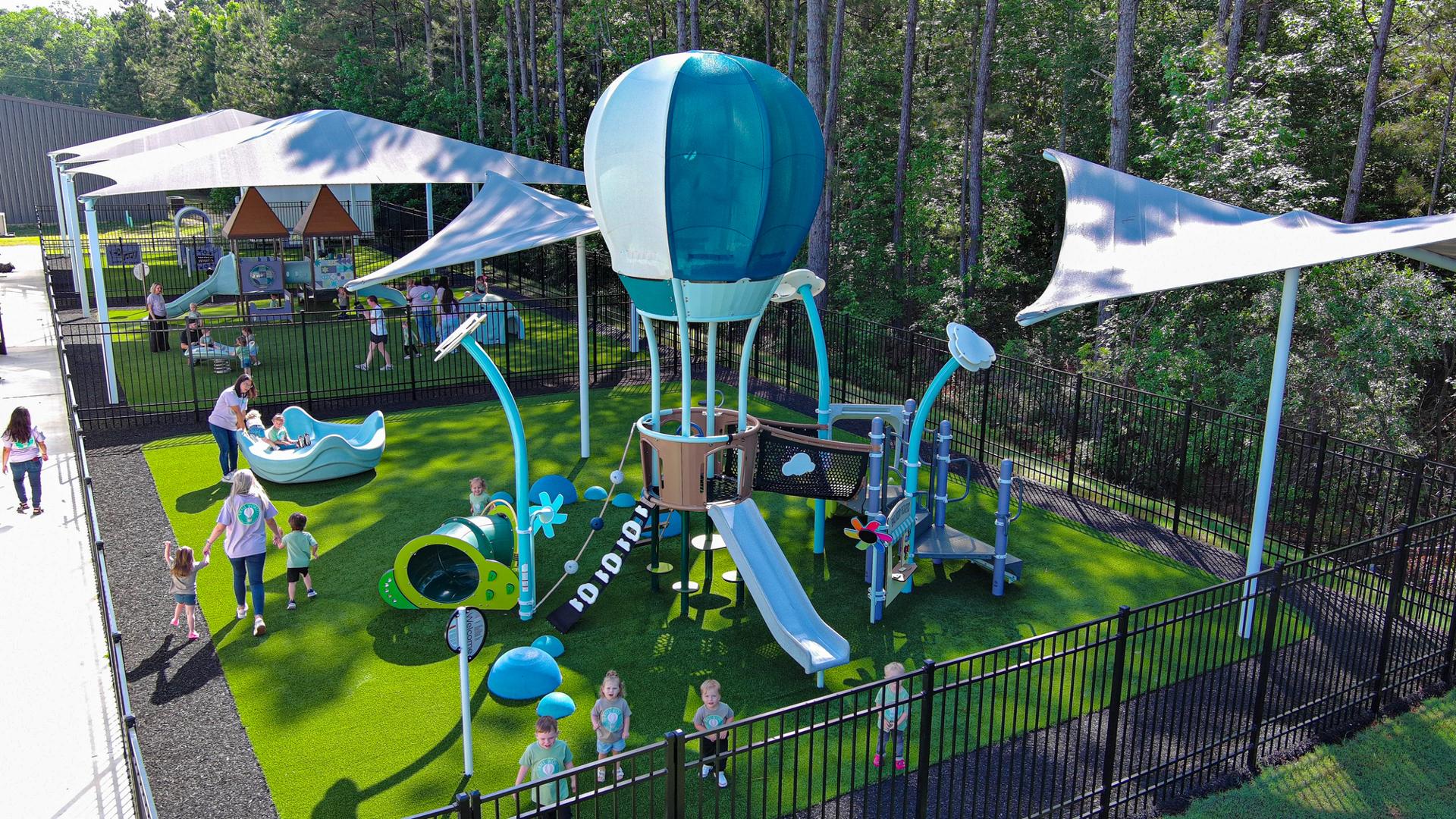 Elevated view of three play areas designated for the age groups of the childcare facility.