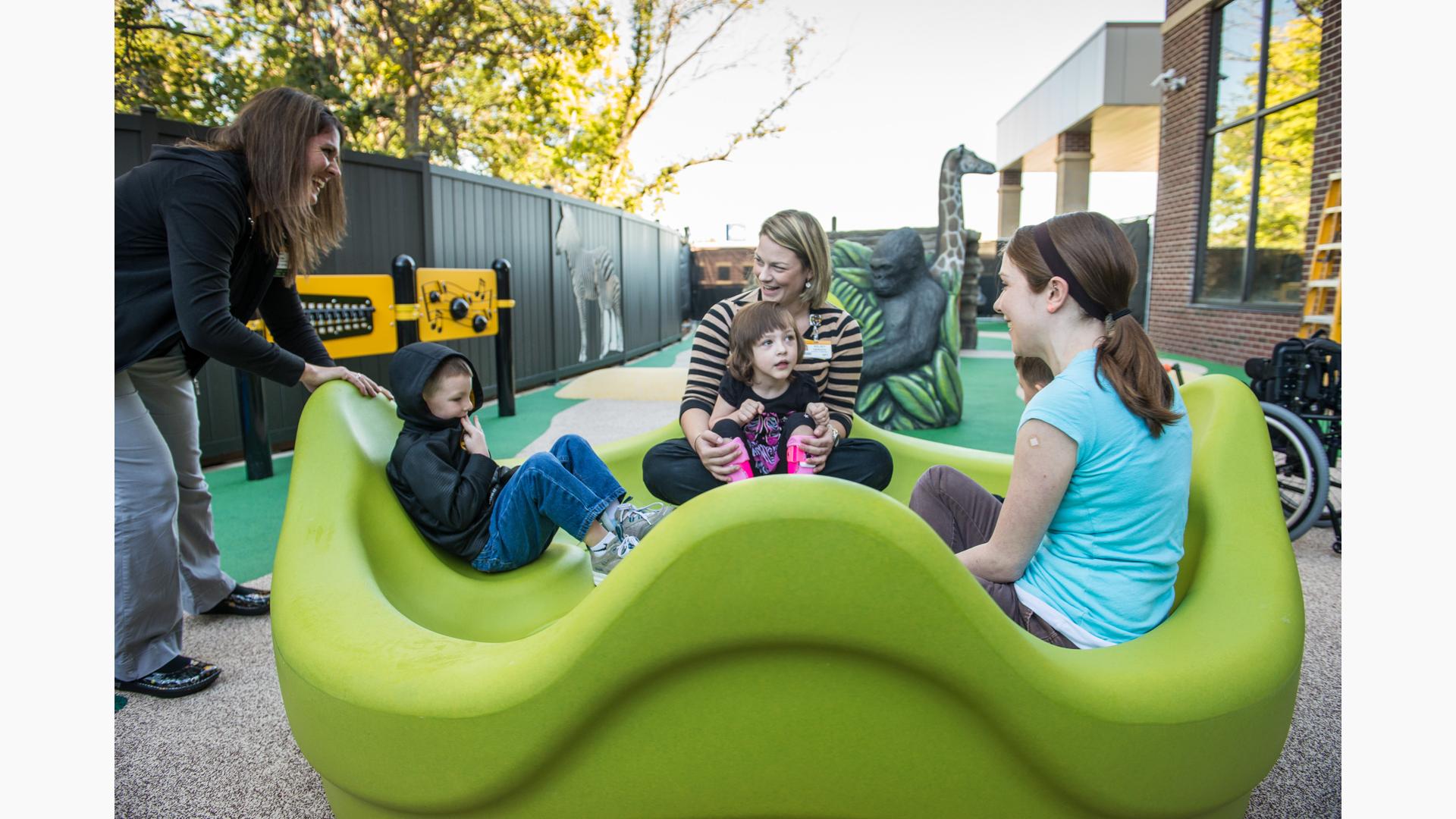 Women playing with children in omnispin Spinner