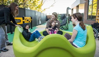 Women playing with children in omnispin Spinner