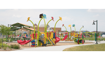New custom Spring-themed playground with big flowers towering over the play structures, reaching up toward the sky. Bug, Bee, and catapillar-themed details add life.