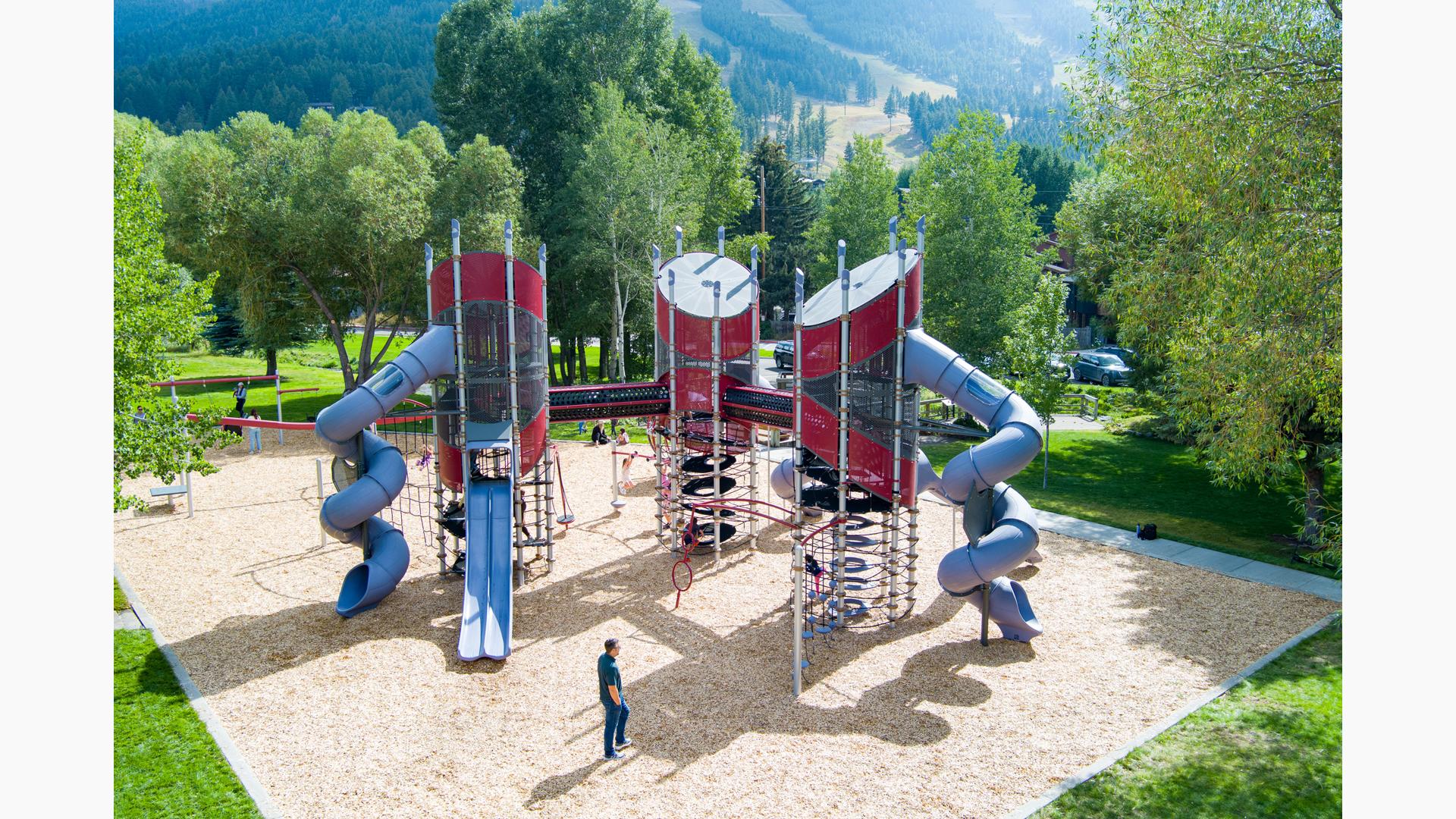 Elevated view of a three tower playground structure connected by elevated crawl tunnels.