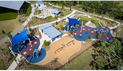 Elevated view of two separate play areas with multiple structures and large blue shades over head.