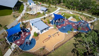 Elevated view of two separate play areas with multiple structures and large blue shades over head.