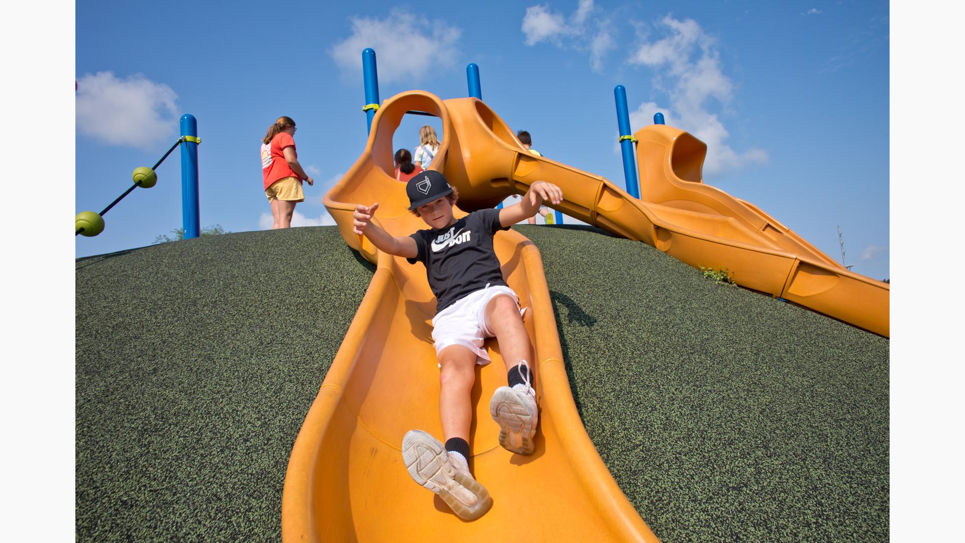 Boy riding down slide