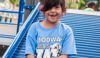 Girl smiling as she sits on Roller Slide