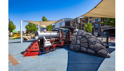 Custom trained-themed playground going through rocky tunnel.
