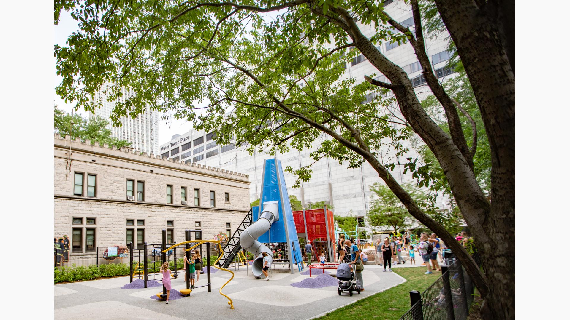 Tunnel slide extending out of blue custom play structure