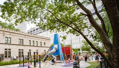 Tunnel slide extending out of blue custom play structure