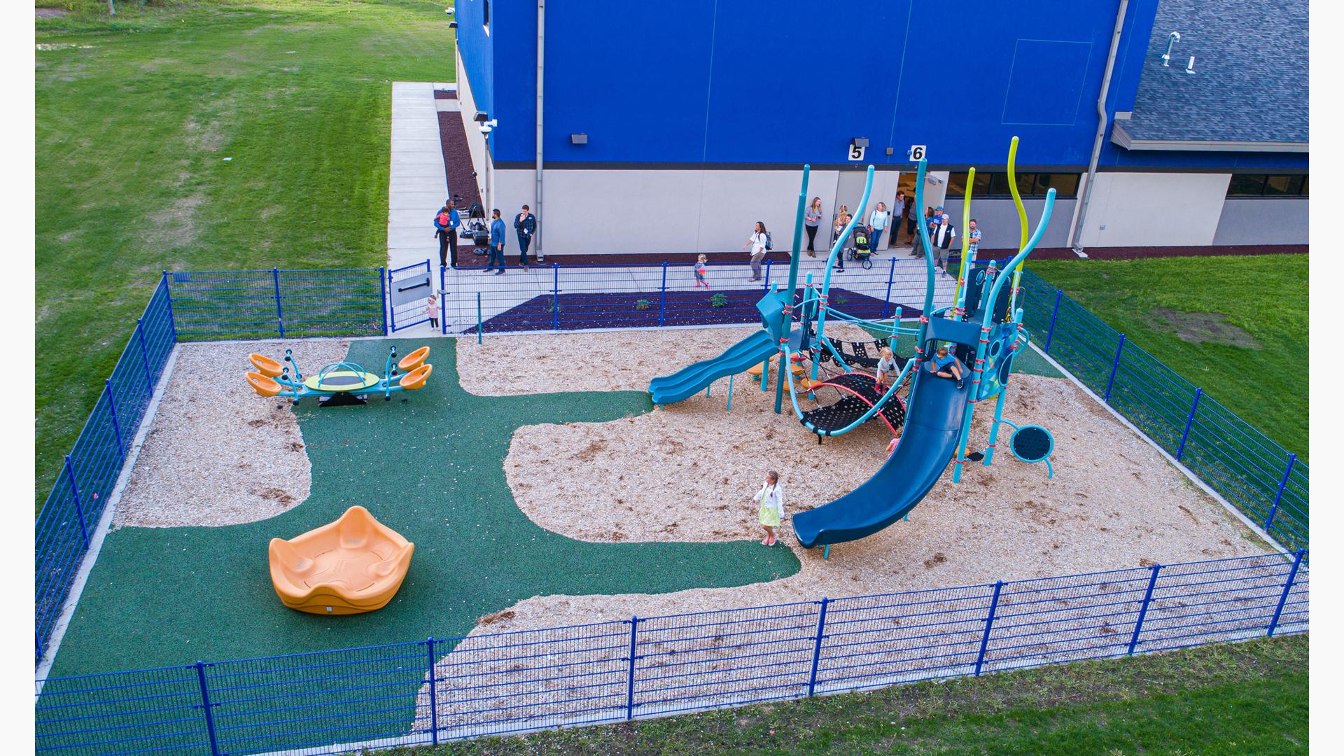 Families walking out to see Up North Learning Center playground with Smart Play play structure.