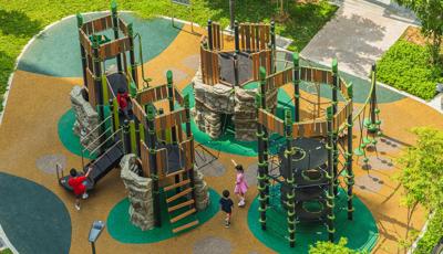 Elevated view of multiple towered structures with rope, rock climbers, and imitation wood paneling.