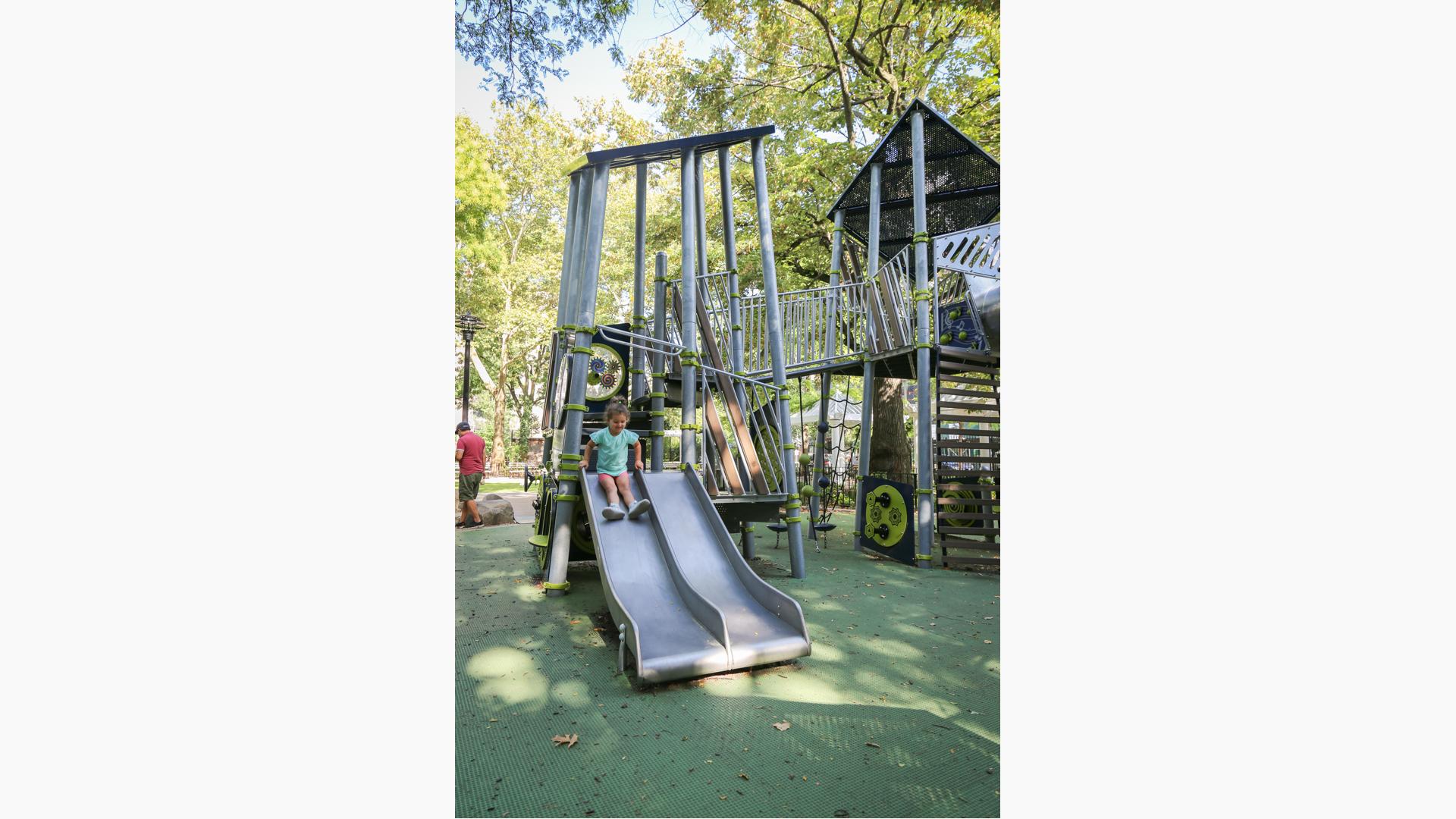 Girl riding down Play Shaper slide