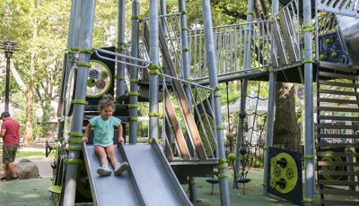 Girl riding down Play Shaper slide