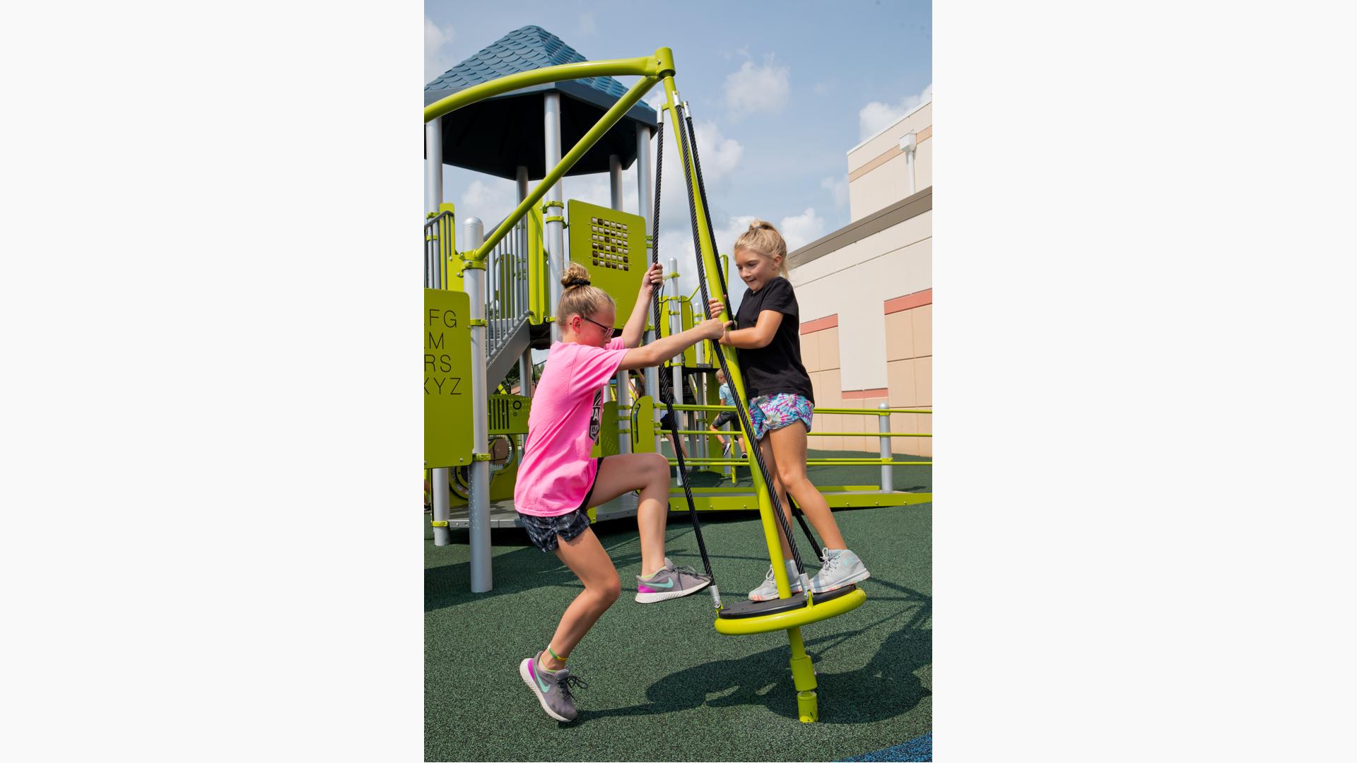 Two girls play on Sol Spinner™