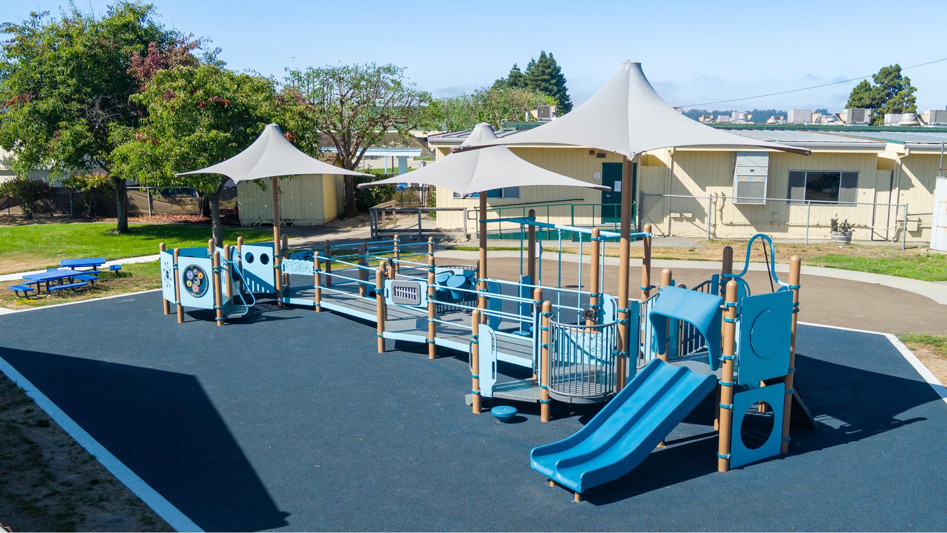 Elevated view of a school playground with dark blue safety surfacing.