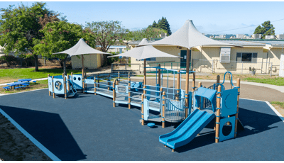 Elevated view of a school playground with dark blue safety surfacing.
