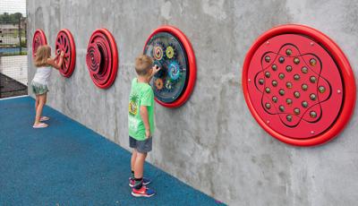 A boy and girl playing with wall mounted games at Prairie Creek Park.