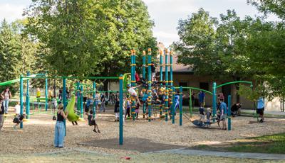 Wood Ranch Playground where kids and families have packed in the playground. The Netplex is especially overrun with playful children. Mothers push their kids on the swings as a dad pushes kids on a Boogie board.