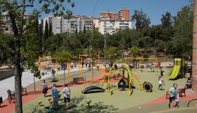 Full view of a large open play area with inclusive safety surfacing with multiple play structures for all ages along with a zip line and swing set area.