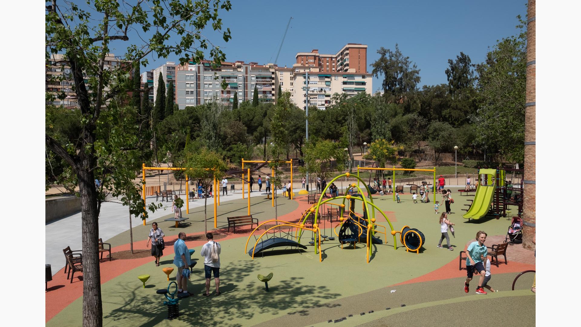 Full view of a large open play area with inclusive safety surfacing with multiple play structures for all ages along with a zip line and swing set area.