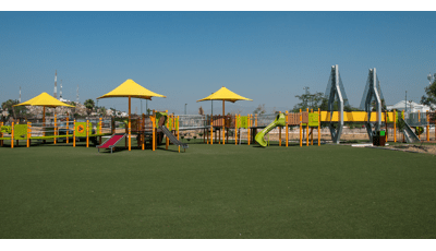 Inclusive playground with lots of ramps and shade with green synthetic surfacing. There is a bridge that is mimic to the famous Baluarte Bridge. 