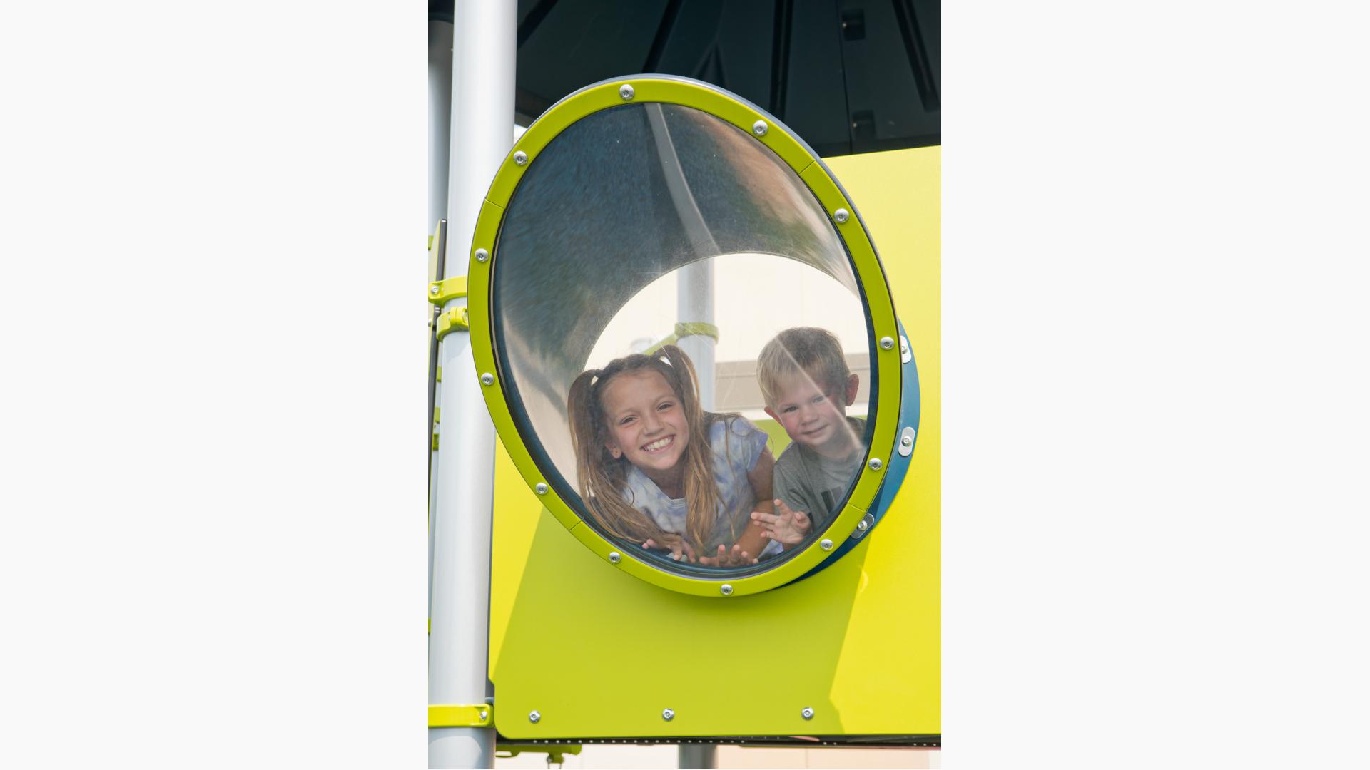 Girl and boy smiling in slant window panel