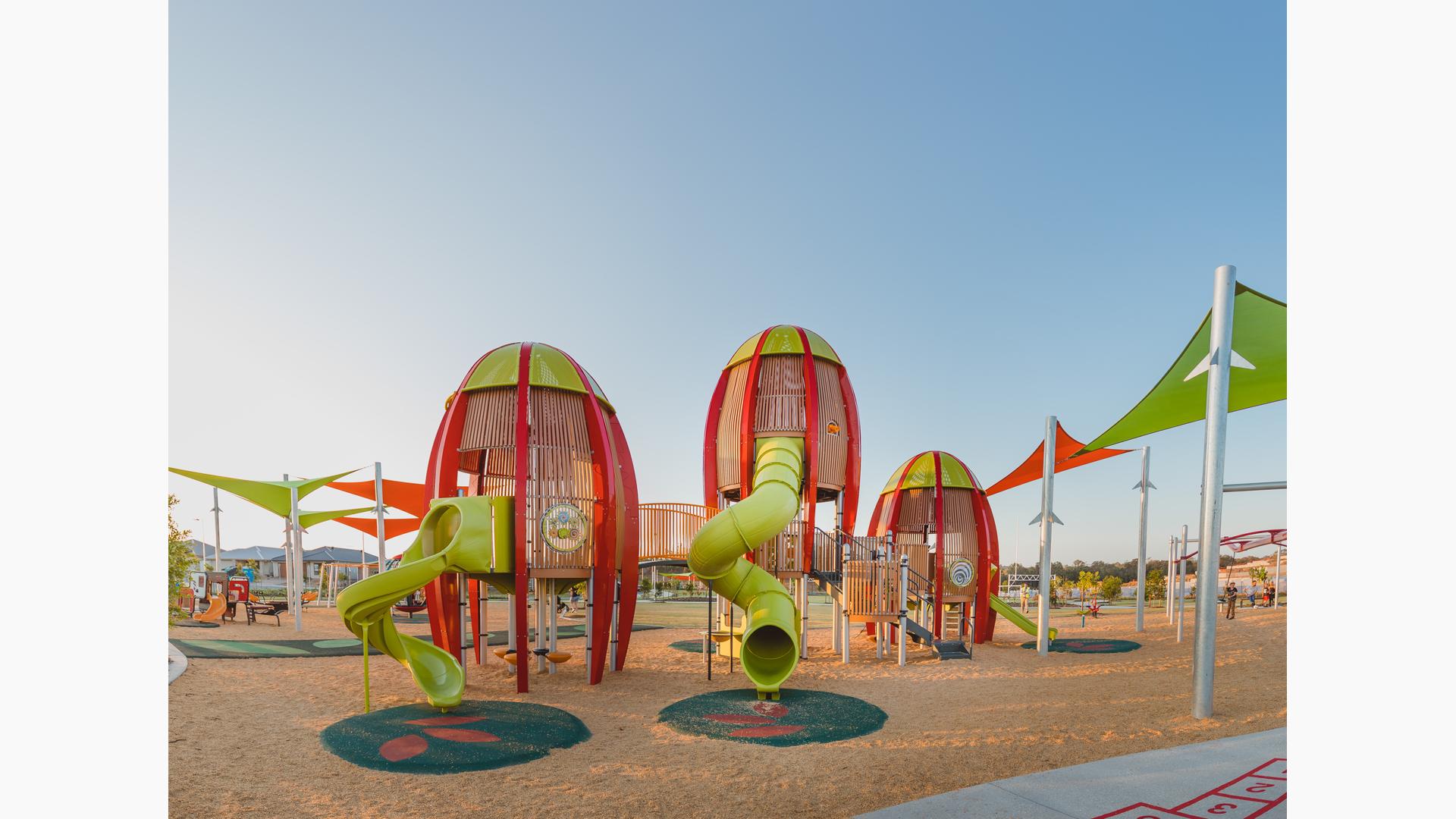 Faye Carr Park Ripley Australia featuring three rocket-shaped tower play structures for 5 to 12.  In addition a Cube play structure for kids ages 2 to 5, and to round out this play environment, a double ZipKrooz®, Global Motion®, We-saw™.