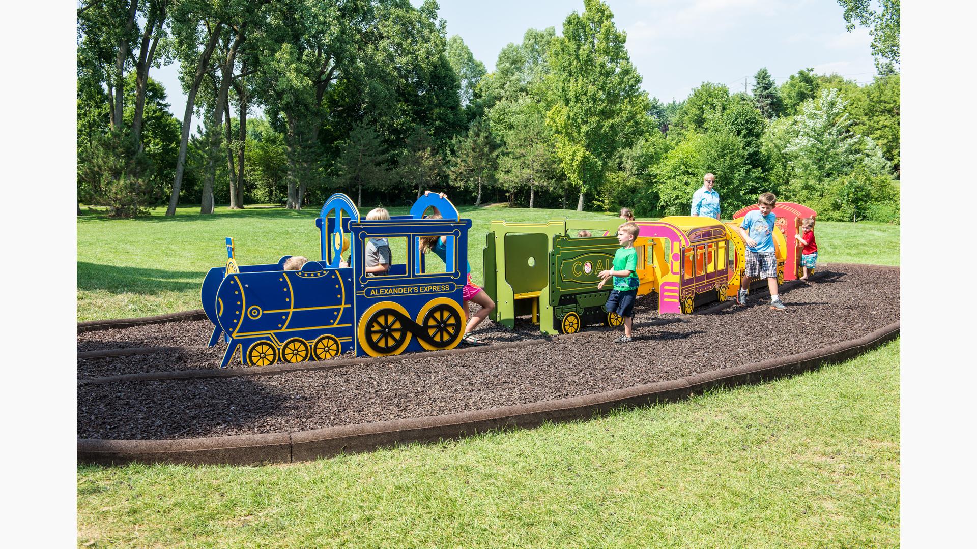 Kids play on the different colored train cars of a play structure. 