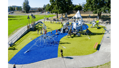Elevated view of a mountain and nature themed playground filled with children.
