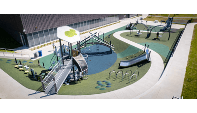Elevated view of a playground set next to a community center building. 