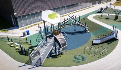 Elevated view of a playground set next to a community center building. 