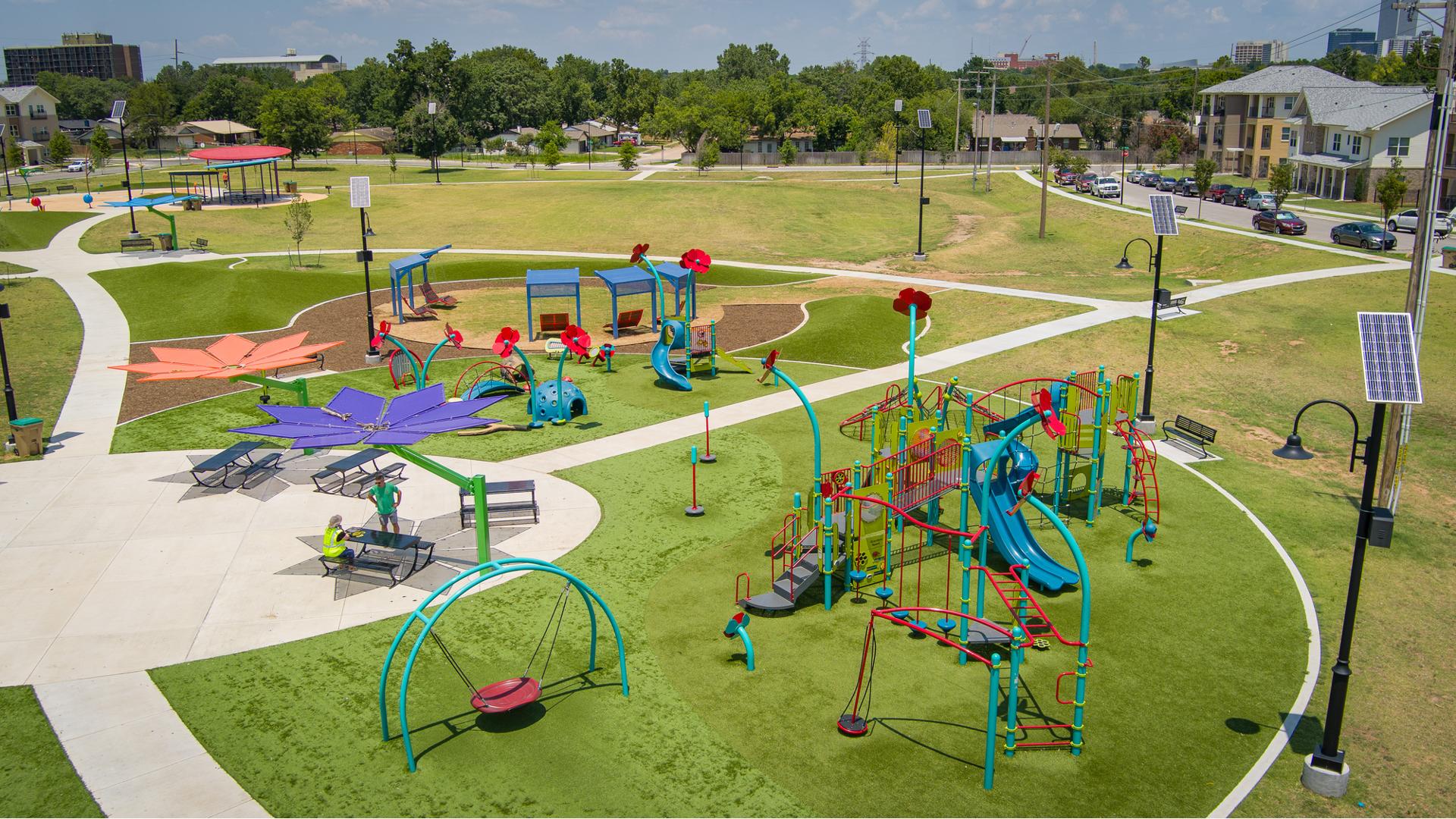 Elevated view of a flower and insect themed playground ground equipment at a town park.