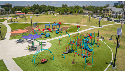 Elevated view of a flower and insect themed playground ground equipment at a town park.