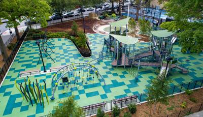 Elevated view of a city nature themed playground with scattered square safety tile surfacing in different shades of green.
