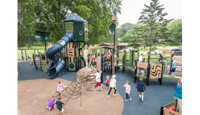 Ship-themed custom PlayBooster play structure with children of all abilities using the ramps to get around. Nature-inspired Adventurescapes climber leads to net below.