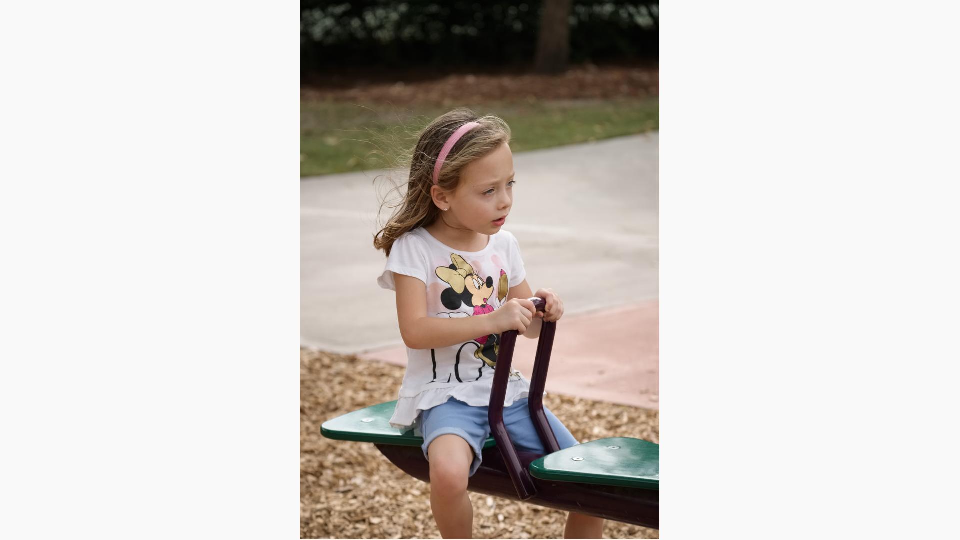 Girl sitting on see-saw