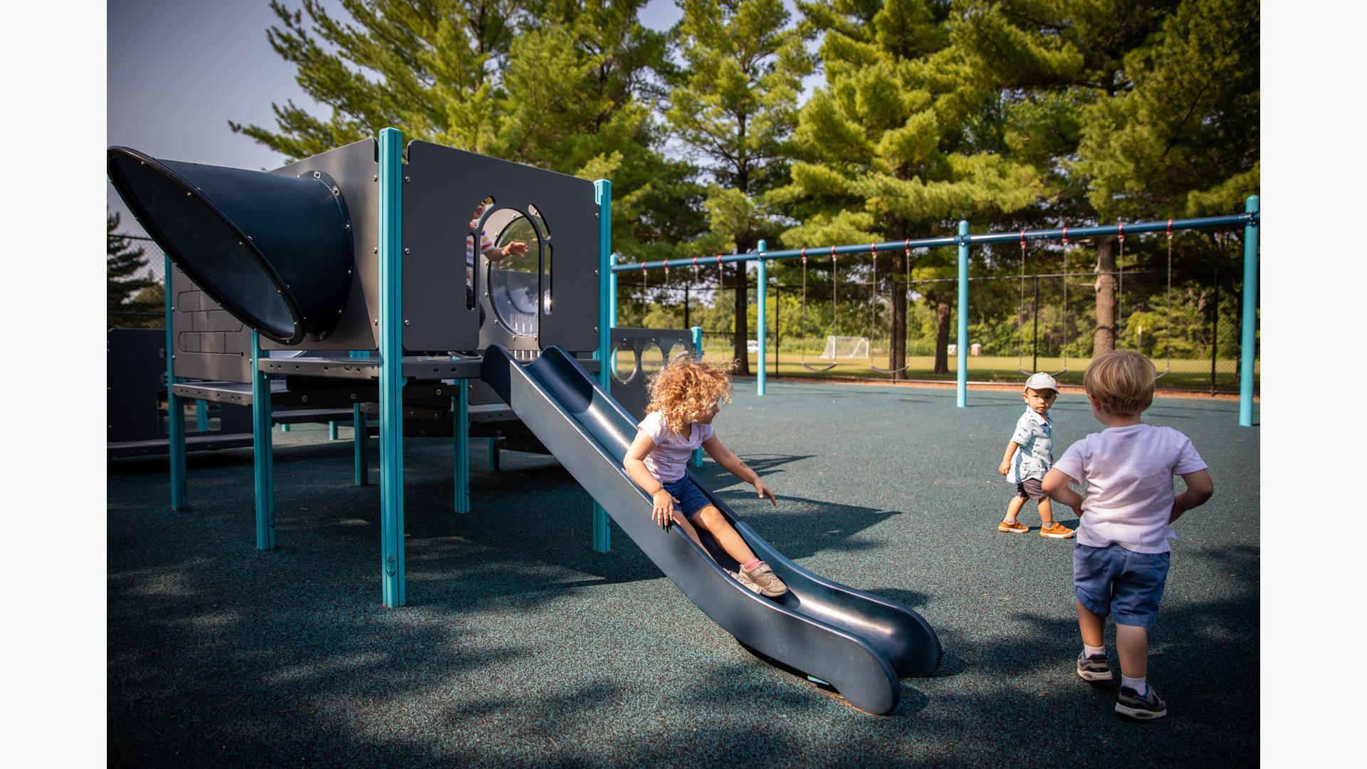 Child riding down PlayShaper® slide