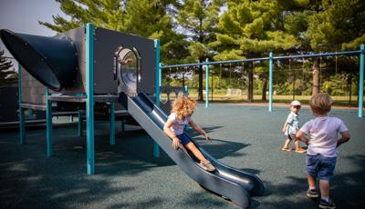 Child riding down PlayShaper® slide