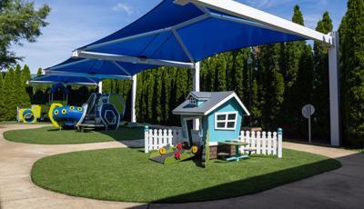Three large blue rectangular shades cover three separate play structures for young children. 