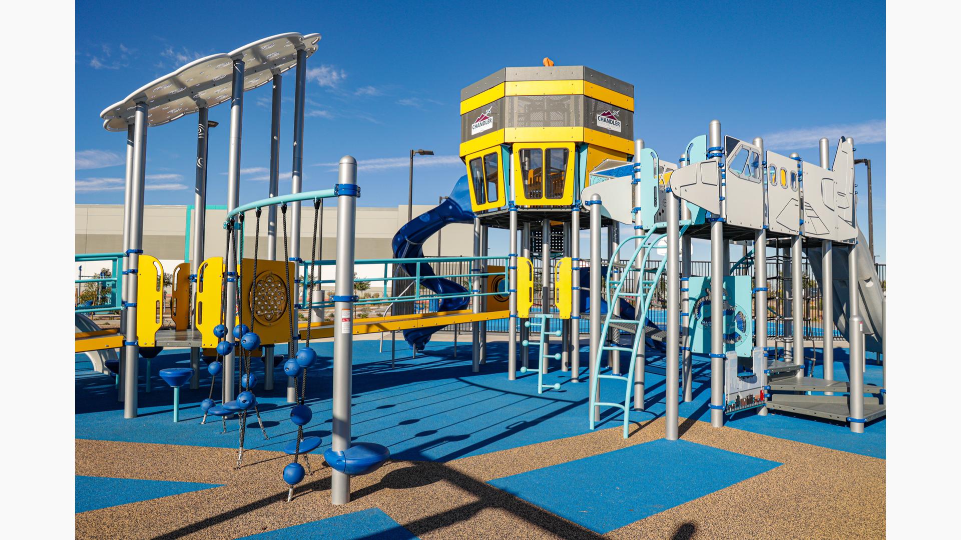 Play structure made of ramps, climbers and slides designed like an airport control tower and jet airplane.